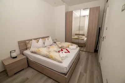 a bedroom with a bed with white sheets and a mirror at Junior Deluxe 2 in Merano