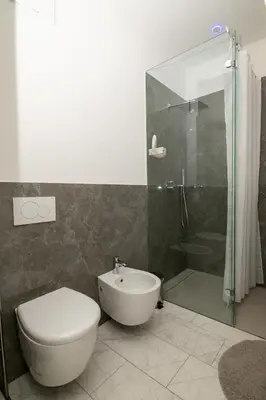 a bathroom with a shower and a toilet and a sink at Junior Deluxe 2 in Merano