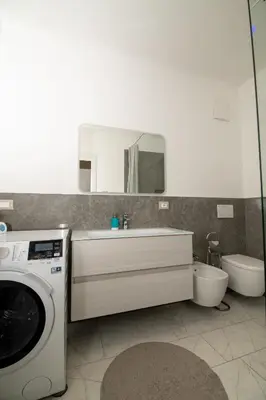 a bathroom with a washing machine and a sink at Junior Deluxe 3 in Merano