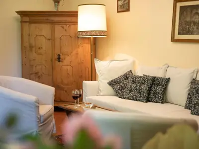 a living room with a white couch with pillows and a table at Villa Atelier Baron Killi in Caldaro