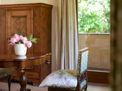 a room with a table and a vase with flowers on it at Villa Atelier Baron Killi in Caldaro