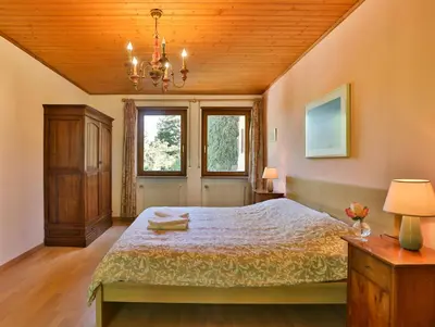 a bedroom with a bed and a wooden ceiling at Villa Atelier Baron Killi in Caldaro