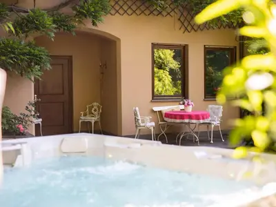a hot tub in a patio with a table and chairs at Villa Atelier Baron Killi in Caldaro