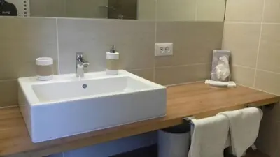a bathroom with a white sink and a mirror at Garni Raffein in Lana