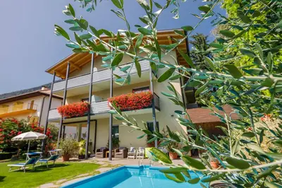 a house with a swimming pool in front of it at Garni Raffein in Lana