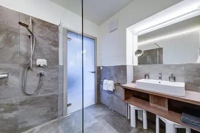 a bathroom with a sink and a shower at Apartments Lichtenberg in Lagundo