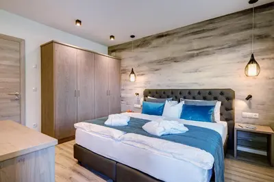a bedroom with a large bed with blue pillows at Apartments Lichtenberg in Lagundo
