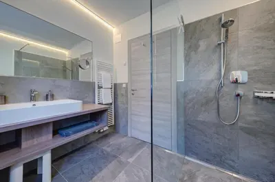 a bathroom with a shower and a sink and a tub at Apartments Lichtenberg in Lagundo