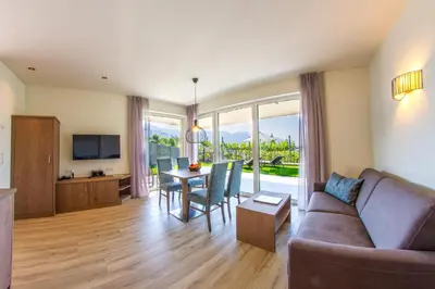 a living room with a couch and a table with chairs at Apartments Lichtenberg in Lagundo
