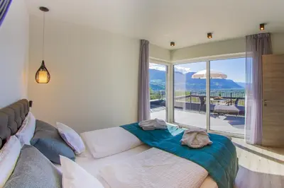 a bedroom with a bed and a view of a balcony at Apartments Lichtenberg in Lagundo