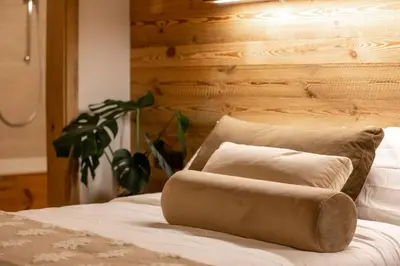 a bed with two pillows on top of it at iFlat Chalet Carole Ortisei in Ortisei