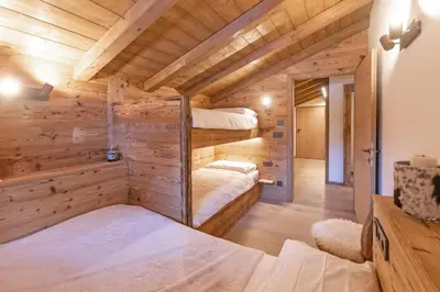 a cabin with two beds in a room with wooden walls at iFlat Chalet Carole Ortisei in Ortisei