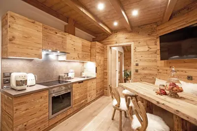 a kitchen with wooden walls and a wooden table at iFlat Chalet Carole Ortisei in Ortisei