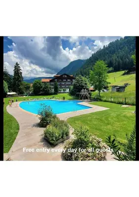 a picture of a swimming pool in a field at iFlat Chalet Carole Ortisei in Ortisei