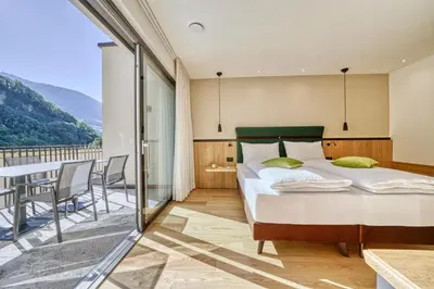 a bedroom with a bed and a balcony at Castanea Appartements in Caines
