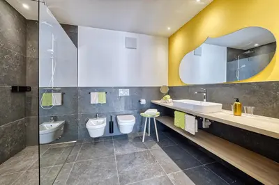a bathroom with two sinks and two toilets at Castanea Appartements in Caines