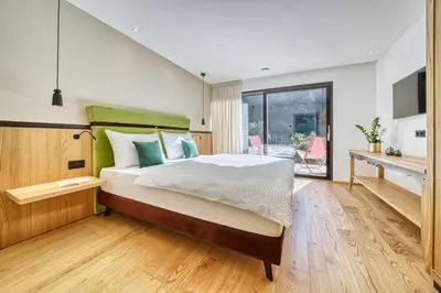 a bedroom with a bed and a desk and a window at Castanea Appartements in Caines