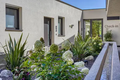a garden in front of a building with flowers at Castanea Appartements in Caines
