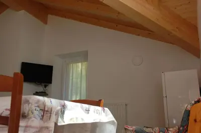 a room with a bed and a television and a window at LA CIESA DEI SIORI in Alleghe