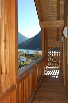 a wooden porch with a view of a lake at LA CIESA DEI SIORI in Alleghe