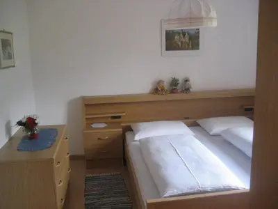 a bedroom with a bed with a desk and a bed sidx sidx sidx at Gandlerhof in Valdaora