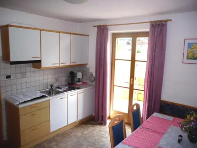 a kitchen with white cabinets and a table and a window at Gandlerhof in Valdaora