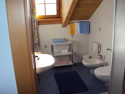 a bathroom with two sinks and a toilet and a window at Gandlerhof in Valdaora
