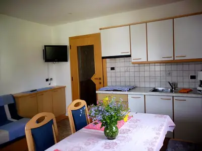 a kitchen with a table with a vase of flowers on it at Gandlerhof in Valdaora