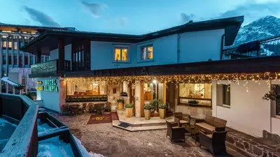 a house in the mountains with lights at Hotel Olimpia in Cortina dʼAmpezzo