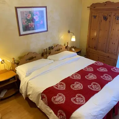 a bedroom with a large bed with a red blanket at Meuble Villa Neve in Cortina dʼAmpezzo