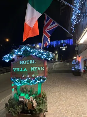a sign for a hotel with christmas lights at Meuble Villa Neve in Cortina dʼAmpezzo