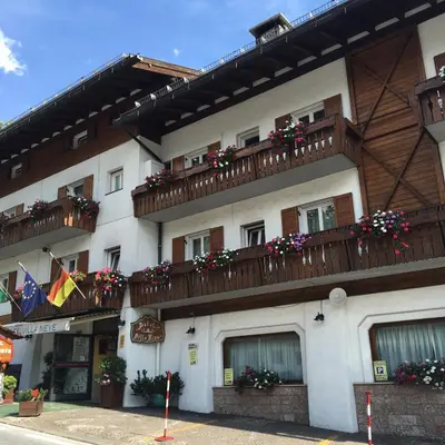 a building with flower boxes and balconies on it at Meuble Villa Neve in Cortina dʼAmpezzo
