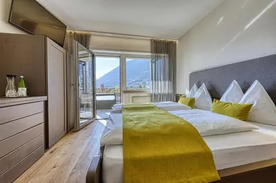 a bedroom with a large bed with a large window at Auhof in Merano