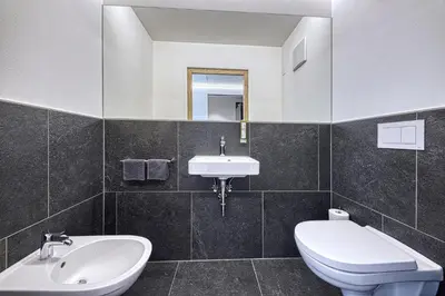 a bathroom with a white toilet and a sink at Auhof in Merano