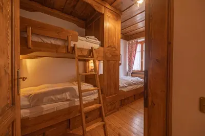 a room with two bunk beds in a cabin at Casa Regoiettes in San Vito di Cadore