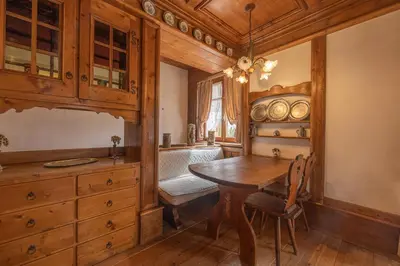 a dining room with a wooden table and a bench at Casa Regoiettes in San Vito di Cadore