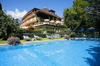 a hotel with a swimming pool in front of a building at Hotel Juliane in Merano
