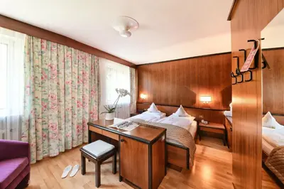 a hotel room with a bed and a desk at Hotel Juliane in Merano
