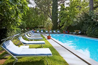 a row of lounge chairs next to a swimming pool at Hotel Juliane in Merano
