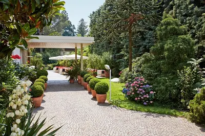a garden with a pathway with plants and flowers at Hotel Juliane in Merano