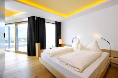 a bedroom with a white bed with a yellow ceiling at Bio & Wellnesshotel Pazeider - Healing Garden above Meran in Marlengo