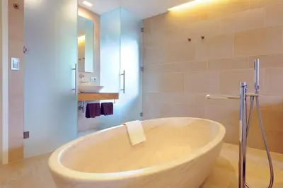 a bath tub in a bathroom with a shower at Bio & Wellnesshotel Pazeider - Healing Garden above Meran in Marlengo
