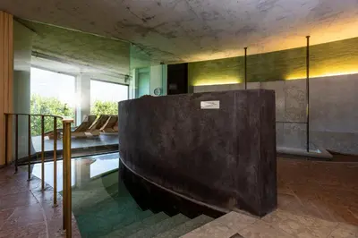 a living room with a large brown couch in a room at Bio & Wellnesshotel Pazeider - Healing Garden above Meran in Marlengo