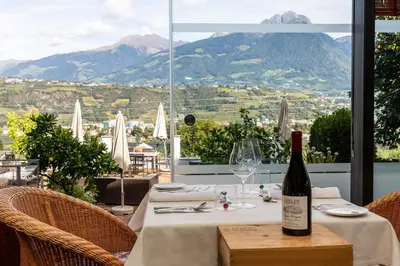 a bottle of wine on a table with a view at Bio & Wellnesshotel Pazeider - Healing Garden above Meran in Marlengo