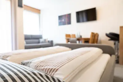 three beds in a living room with a couch at Flow Apartments Astoria in Merano