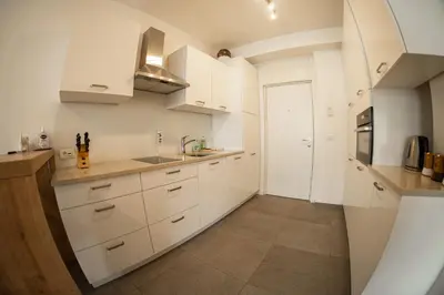 a kitchen with white cabinets and a sink at Flow Apartments Astoria in Merano