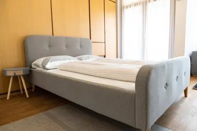 a large bed in a room with a large window at Flow Apartments Astoria in Merano