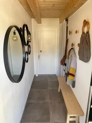 a hallway with a mirror and a bench at B&B La Casa del Sole in Ziano di Fiemme