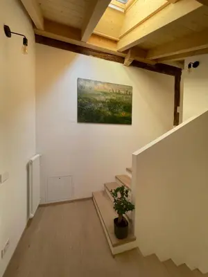 a room with stairs and a painting on the wall at B&B La Casa del Sole in Ziano di Fiemme