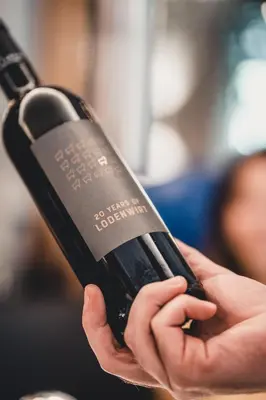 a person is holding a bottle of wine at Aktiv & Genusshotel Lodenwirt in Vandoies